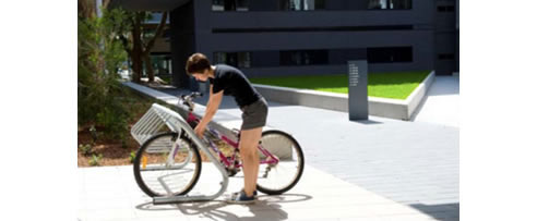 woman parking bicycle in bike rack