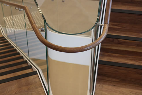 curved glass balustrade and wooden handrail