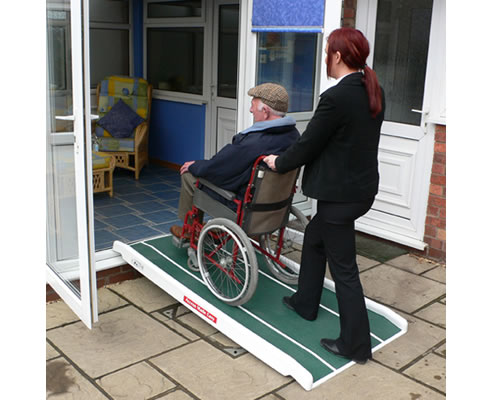 man in a wheelchair utilises mobile access ramp