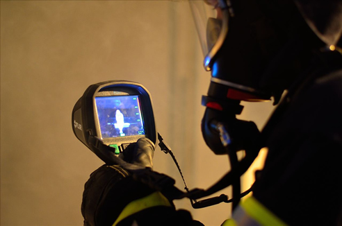 fire fighter operating thermal imaging camera