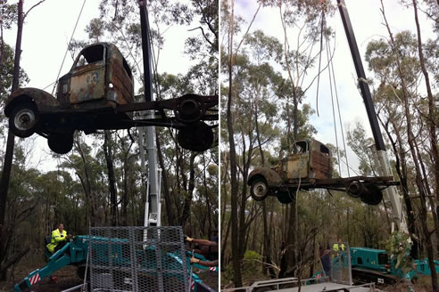 mini crane removing old trucks from bushland