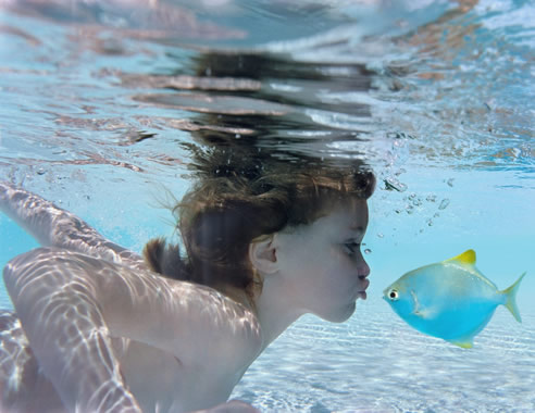 girl underwater kissing fish