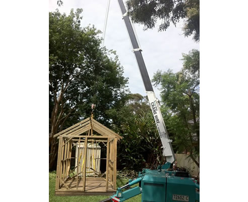 mini crane moving small shed