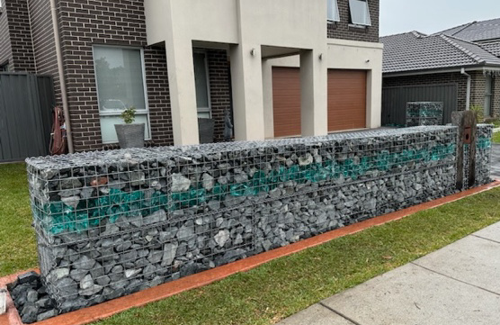 Gabion Fence with Glass Landscaping Rocks by Schneppa Glass