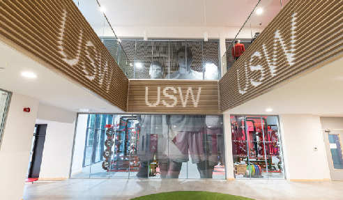 In entry atrium on the walls below the balustrade, the client's identity has been incorporated into them the slatted panels with the open areas of the letters highlighted with a lighter background.