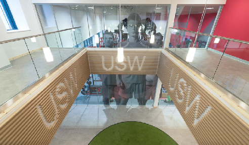 In entry atrium on the walls below the balustrade, the client's identity has been incorporated into them the slatted panels with the open areas of the letters highlighted with a lighter background.